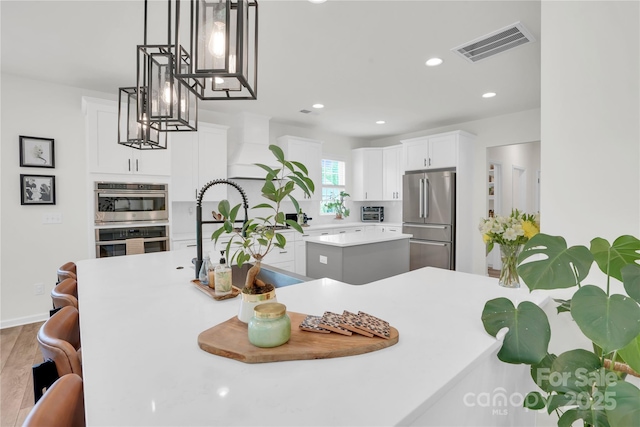 dining space with wood finished floors, an inviting chandelier, a toaster, visible vents, and recessed lighting