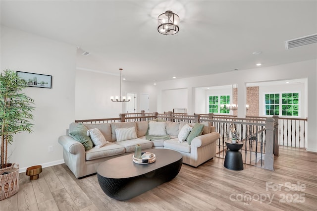 living room with light wood-style floors, baseboards, a notable chandelier, visible vents, and recessed lighting
