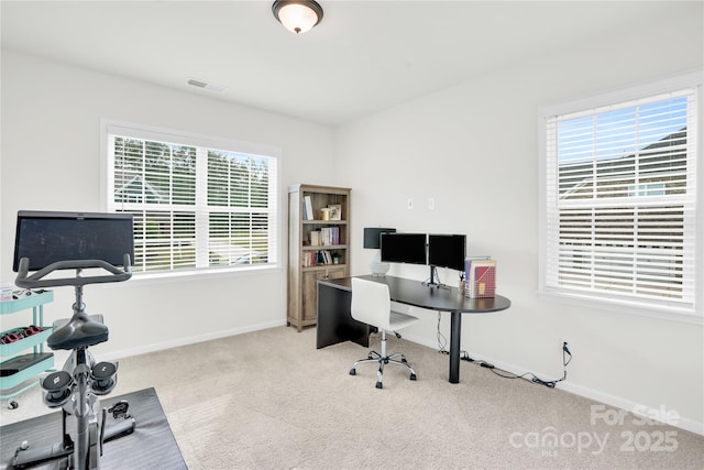 home office with carpet flooring, visible vents, and plenty of natural light