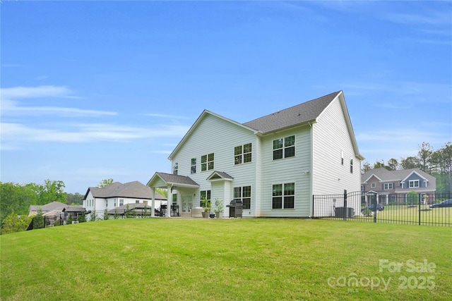rear view of property featuring fence, a yard, and a patio