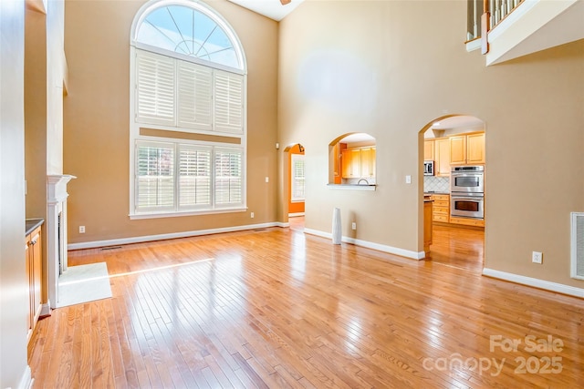 4333 Sawmill Trace Dr, Charlotte, NC 28213 - unfurnished living room featuring a high ceiling, light wood finished floors, baseboards, and visible vents