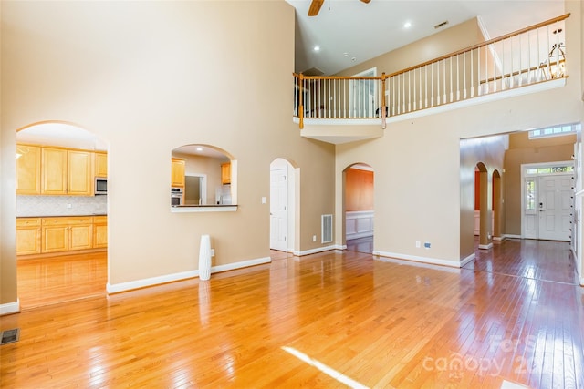 4333 Sawmill Trace Dr, Charlotte, NC 28213 - unfurnished living room with light wood-type flooring, a high ceiling, ceiling fan, and visible vents
