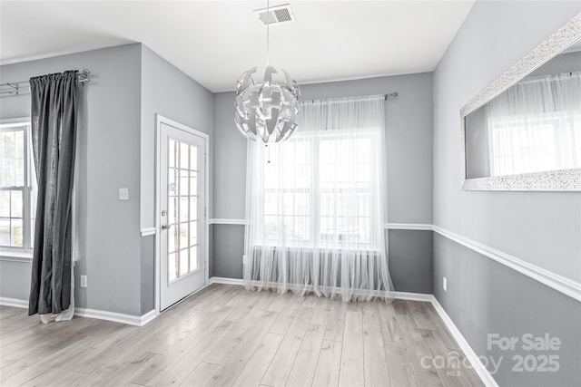 2059 Lennox Square Rd, Charlotte, NC 28210 - unfurnished dining area with a chandelier, wood finished floors, and plenty of natural light