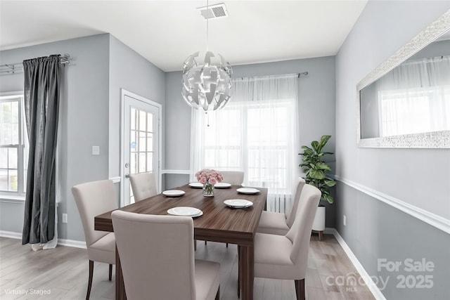 2059 Lennox Square Rd, Charlotte, NC 28210 - dining space with light wood finished floors, baseboards, and a chandelier