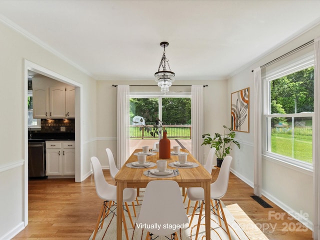915 Gate Rd, Monroe, NC 28112 - dining room with healthy amount of natural light, light wood-style floors, crown molding, and baseboards