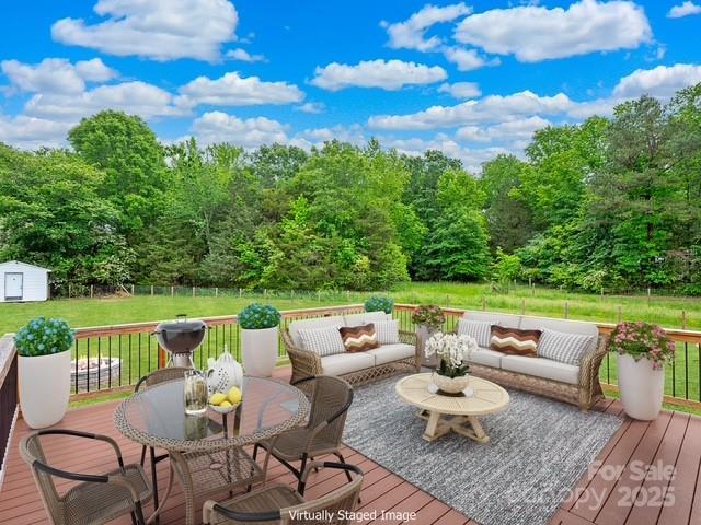 915 Gate Rd, Monroe, NC 28112 - wooden deck with outdoor lounge area, a shed, a lawn, and an outbuilding