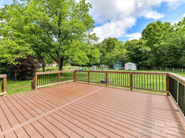 915 Gate Rd, Monroe, NC 28112 - wooden deck featuring a shed, an outbuilding, and view of wooded area
