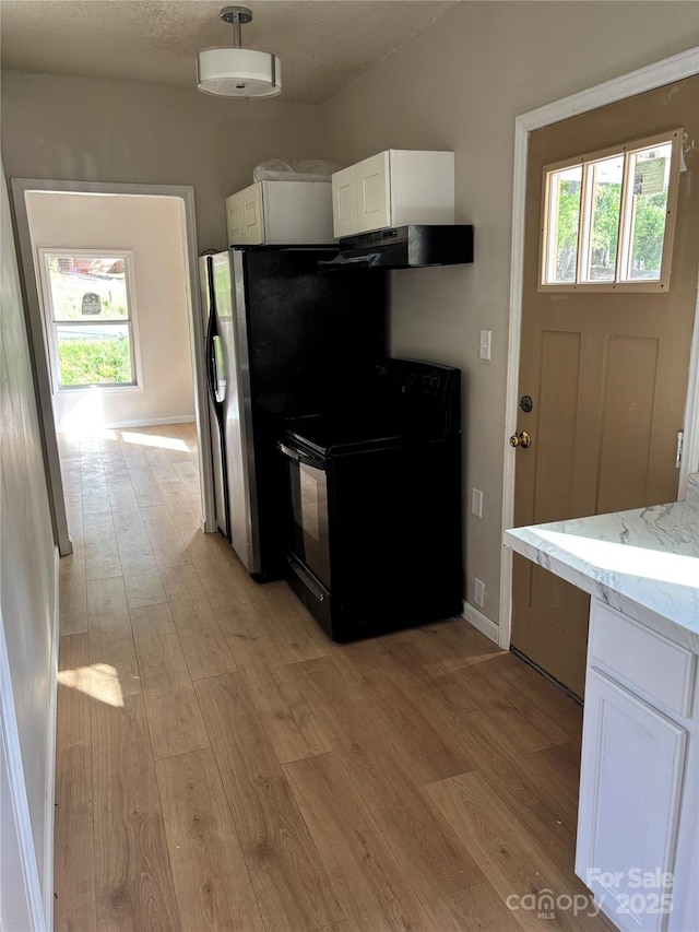 kitchen with light wood-style flooring, under cabinet range hood, black electric range, and white cabinetry