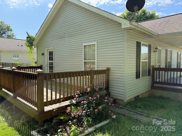 back of house with a wooden deck and a shingled roof