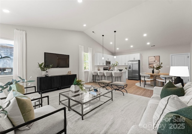 living room featuring recessed lighting, vaulted ceiling, and light wood finished floors