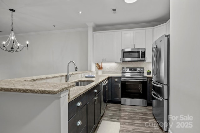 18700 Nautical Dr Unit 203, Cornelius, NC 28031 - kitchen with appliances with stainless steel finishes, white cabinetry, crown molding, light stone countertops, and a chandelier