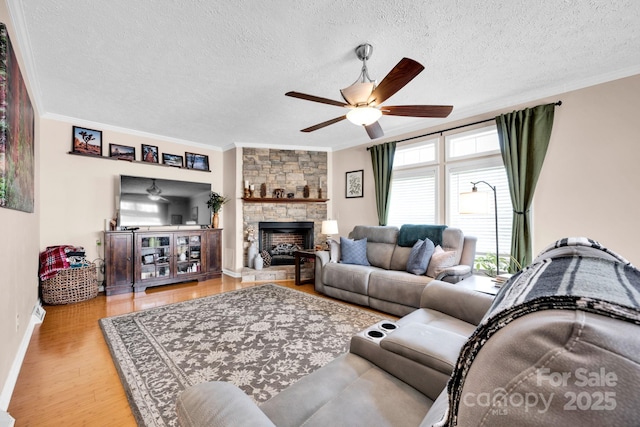 126 Top Flite Dr, Statesville, NC 28677 - living room featuring wood finished floors, a stone fireplace, crown molding, and ceiling fan