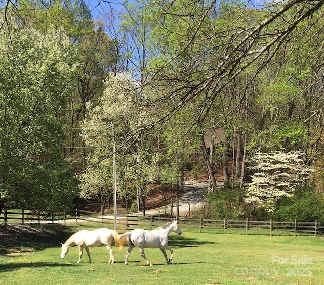 view of home's community with fence and a yard