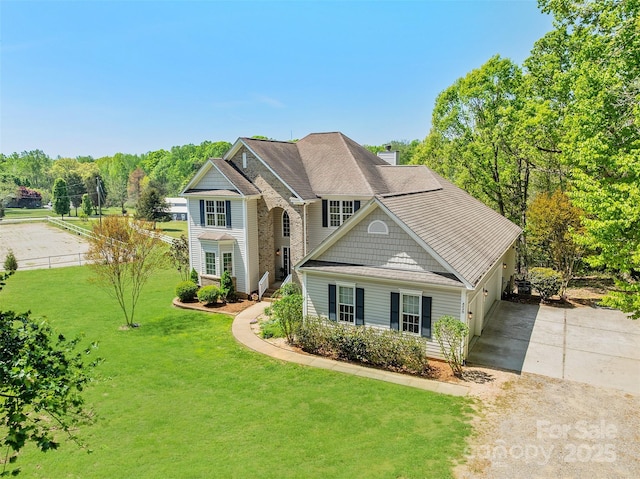 view of front of home featuring a garage, driveway, a front lawn, and fence