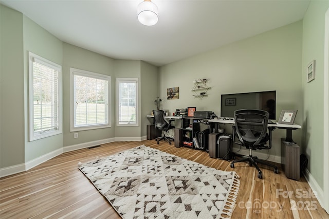 office space with visible vents, baseboards, and wood finished floors