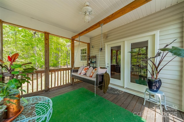 sunroom featuring ceiling fan, a healthy amount of sunlight, and beamed ceiling