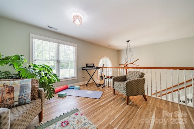 interior space featuring baseboards, wood finished floors, and visible vents
