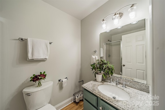 bathroom with a shower with door, wood finished floors, toilet, vanity, and baseboards