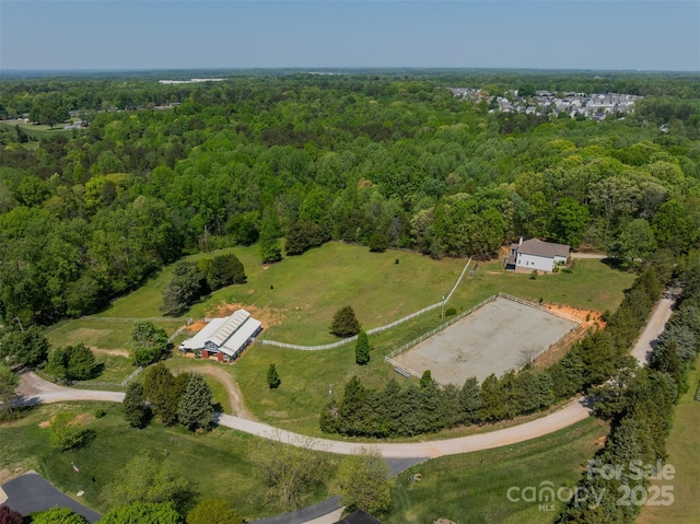 drone / aerial view featuring a wooded view