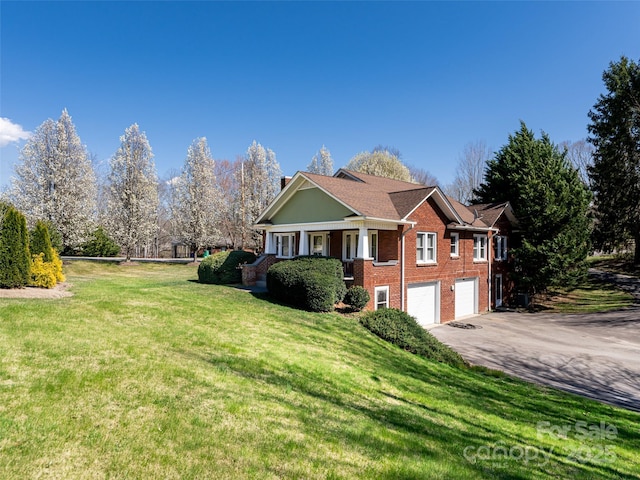 view of front of property with aphalt driveway, brick siding, a front lawn, and an attached garage