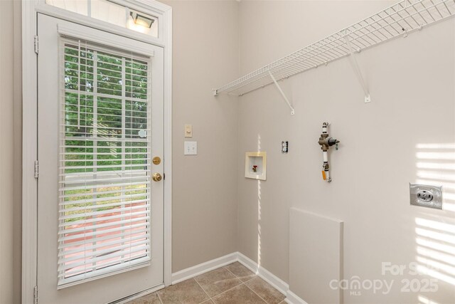 clothes washing area featuring hookup for an electric dryer, light tile patterned floors, baseboards, laundry area, and washer hookup