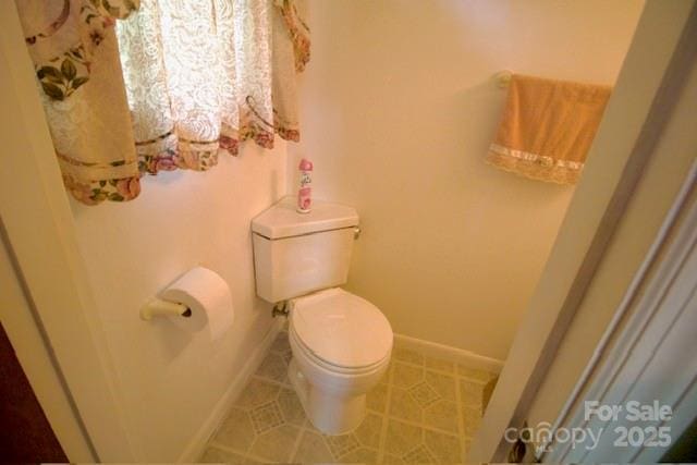 bathroom featuring tile patterned floors, baseboards, and toilet