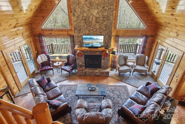 475 S Toe River Rd, Burnsville, NC 28714 - living room with high vaulted ceiling, wood walls, a fireplace, and hardwood / wood-style flooring