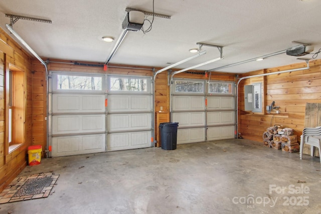 475 S Toe River Rd, Burnsville, NC 28714 - garage featuring a garage door opener, electric panel, and wood walls