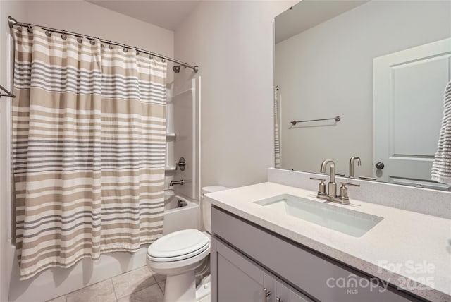 full bath featuring tile patterned floors, shower / bath combo with shower curtain, vanity, and toilet