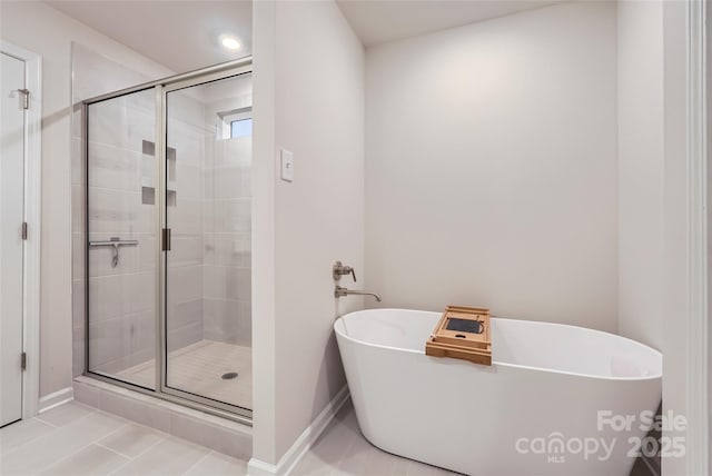 full bathroom featuring baseboards, a shower stall, a soaking tub, and tile patterned flooring