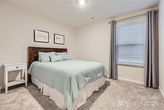 bedroom with baseboards, visible vents, and light carpet