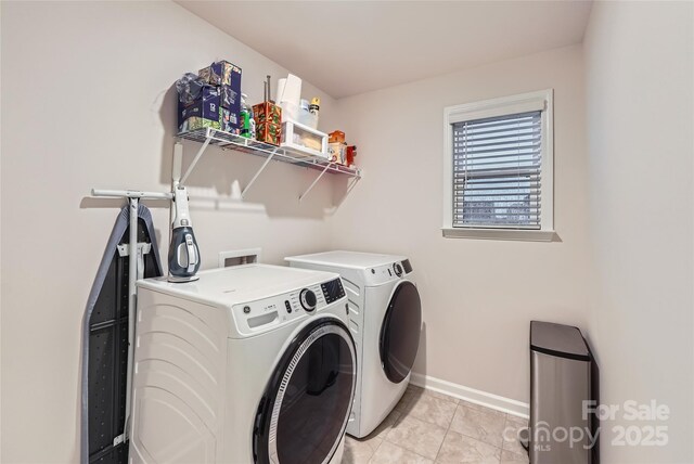 laundry room featuring light tile patterned floors, baseboards, laundry area, and washer and dryer