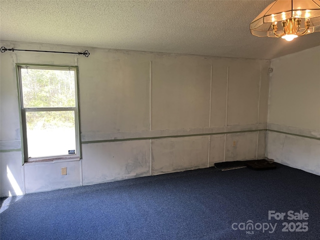 105 Branson Dr, Olin, NC 28660 - unfurnished room with a textured ceiling, an inviting chandelier, and carpet