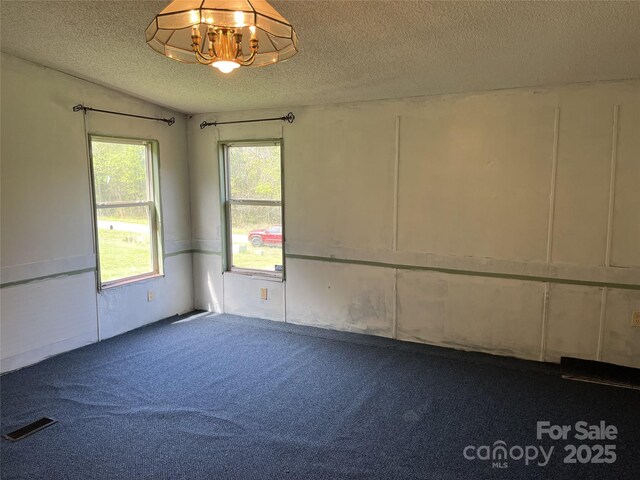 105 Branson Dr, Olin, NC 28660 - spare room featuring dark carpet, a textured ceiling, a chandelier, and visible vents