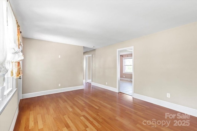 unfurnished room featuring baseboards and light wood-style flooring
