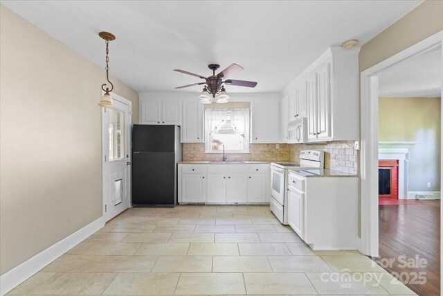 kitchen featuring a fireplace, decorative backsplash, a sink, and white appliances