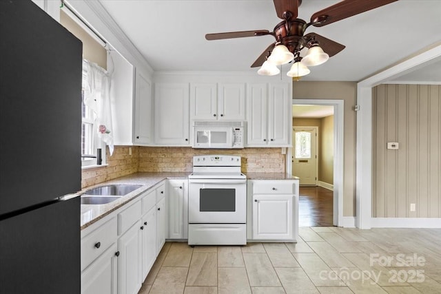kitchen featuring white cabinets, a sink, backsplash, a ceiling fan, and white appliances