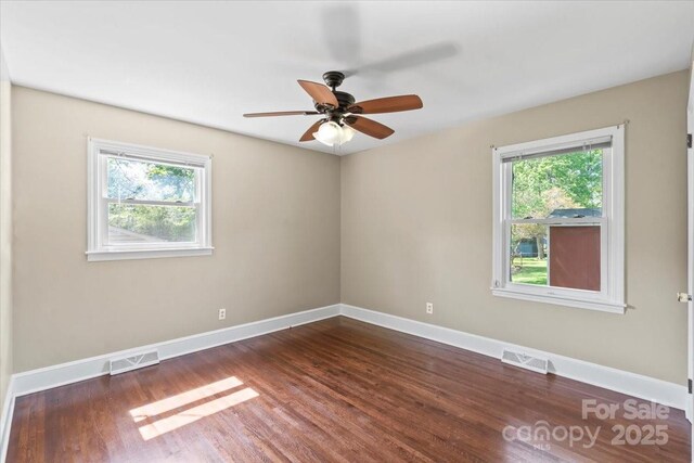 unfurnished room with plenty of natural light, baseboards, and visible vents