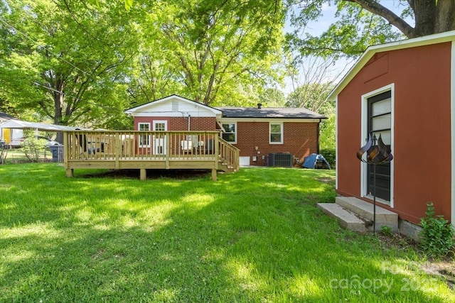 back of property featuring a wooden deck, entry steps, a lawn, and central AC