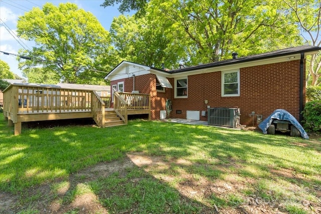 rear view of house with a yard, brick siding, a deck, and cooling unit