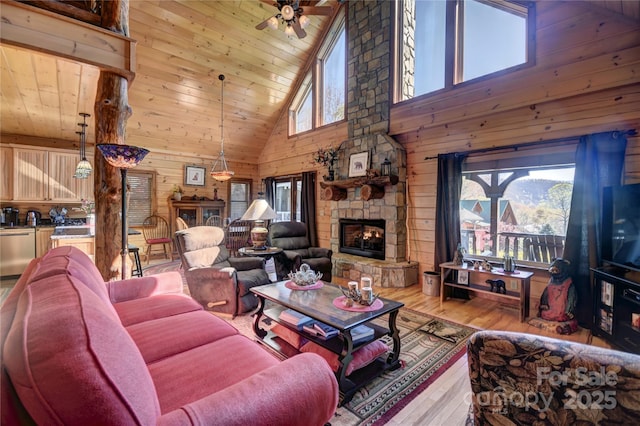 36 Destiny Trl, Maggie Valley, NC 28751 - living room featuring high vaulted ceiling, light wood-type flooring, a fireplace, wooden walls, and a ceiling fan
