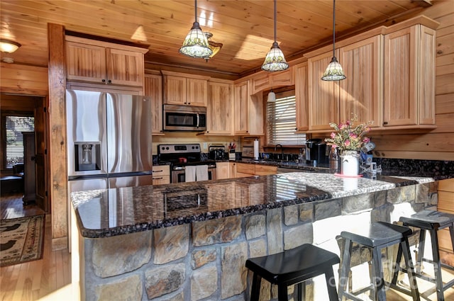 36 Destiny Trl, Maggie Valley, NC 28751 - kitchen featuring appliances with stainless steel finishes, wooden ceiling, hardwood / wood-style floors, dark stone countertops, and pendant lighting