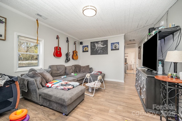 living room with light wood-style floors, baseboards, ornamental molding, and visible vents