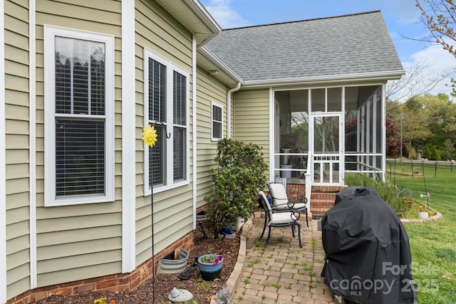 view of patio / terrace featuring a sunroom, a grill, and fence