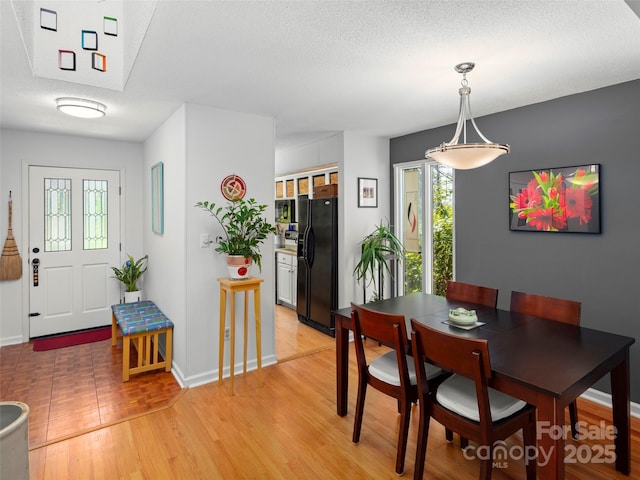 dining room featuring baseboards and light wood finished floors