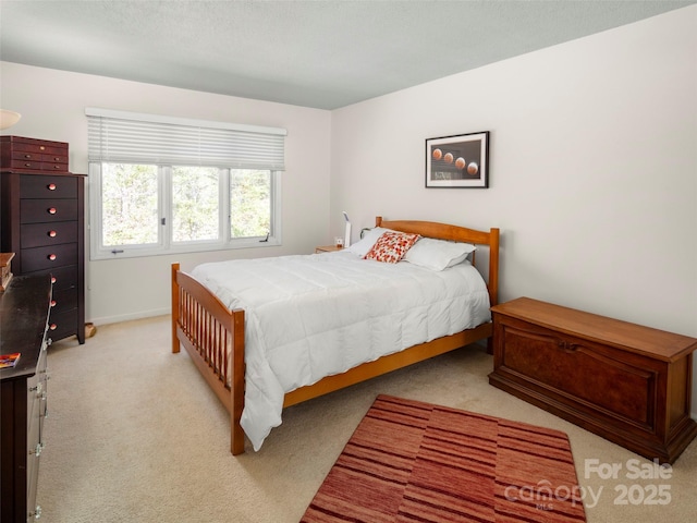 bedroom with baseboards and light colored carpet