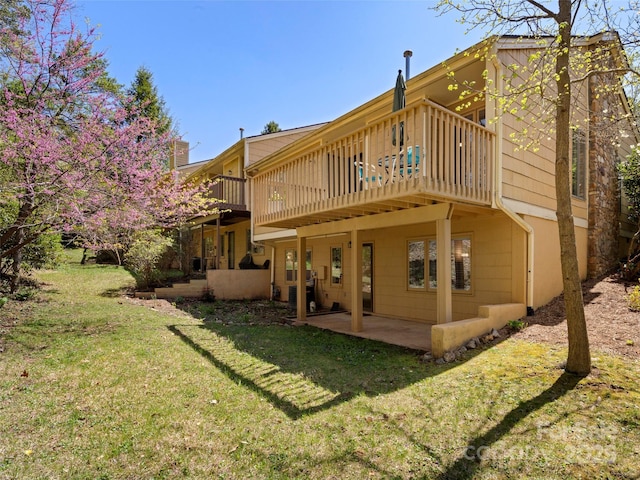 rear view of house featuring a patio, a yard, and a wooden deck