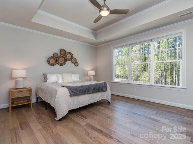 143 Robinson Ridge Dr, Mooresville, NC 28117 - bedroom with visible vents, a tray ceiling, multiple windows, and wood finished floors