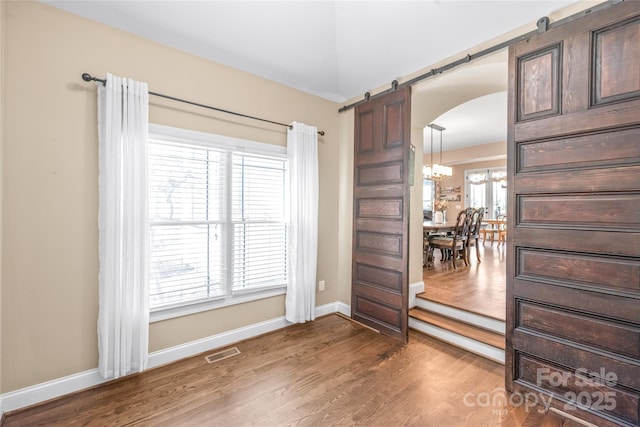 3005 Dream Catcher Cir, Fort Mill, SC 29715 - spare room with visible vents, arched walkways, wood finished floors, and a chandelier