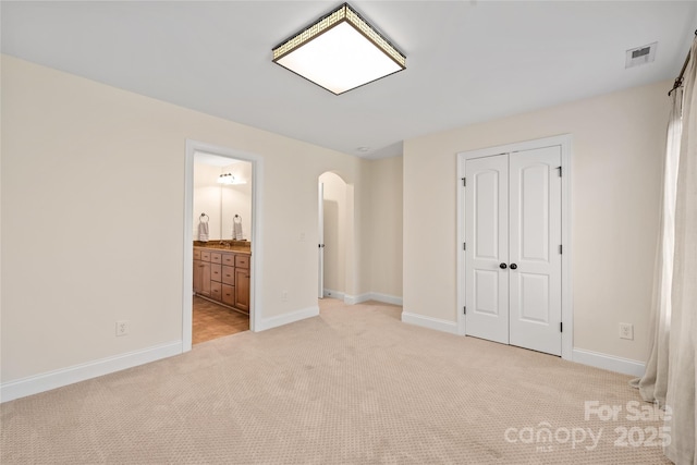 3005 Dream Catcher Cir, Fort Mill, SC 29715 - unfurnished bedroom with visible vents, a closet, light carpet, baseboards, and arched walkways